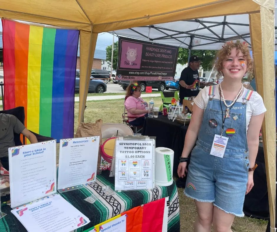 IDEA scholarship winner in front of booth
